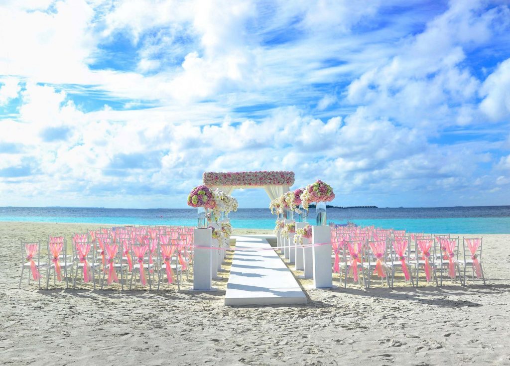 outdoor wedding on the beach with floral aisle